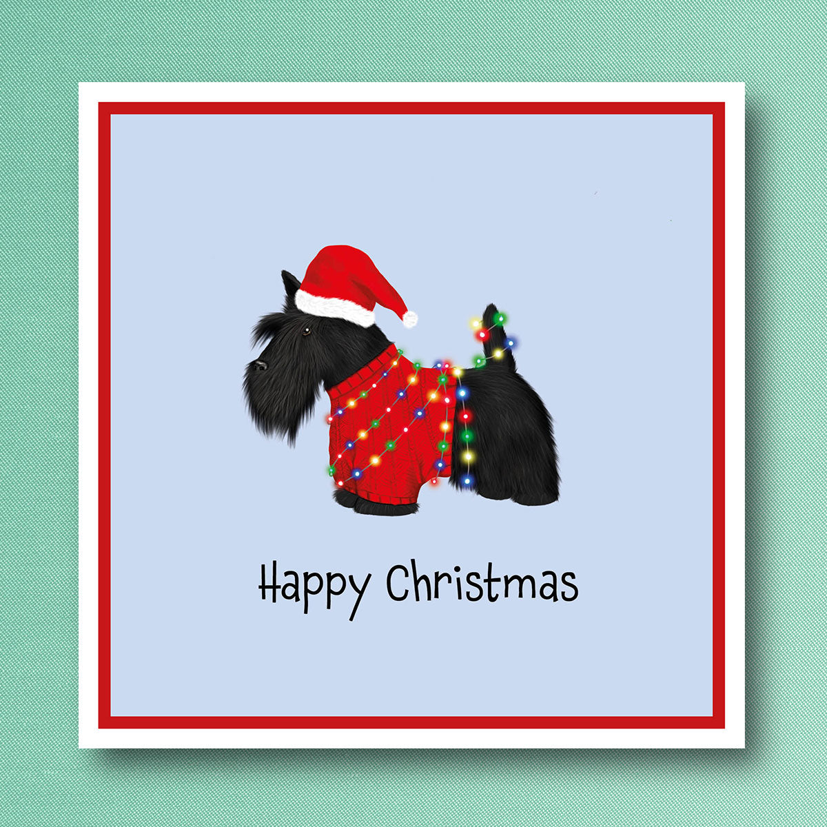 Scottish terrier in Red jumper wrapped in Christmas tree lights with Santa hat on. Christmas Card illustrated by Oundle, Peterborough Artis Kitty's Art.